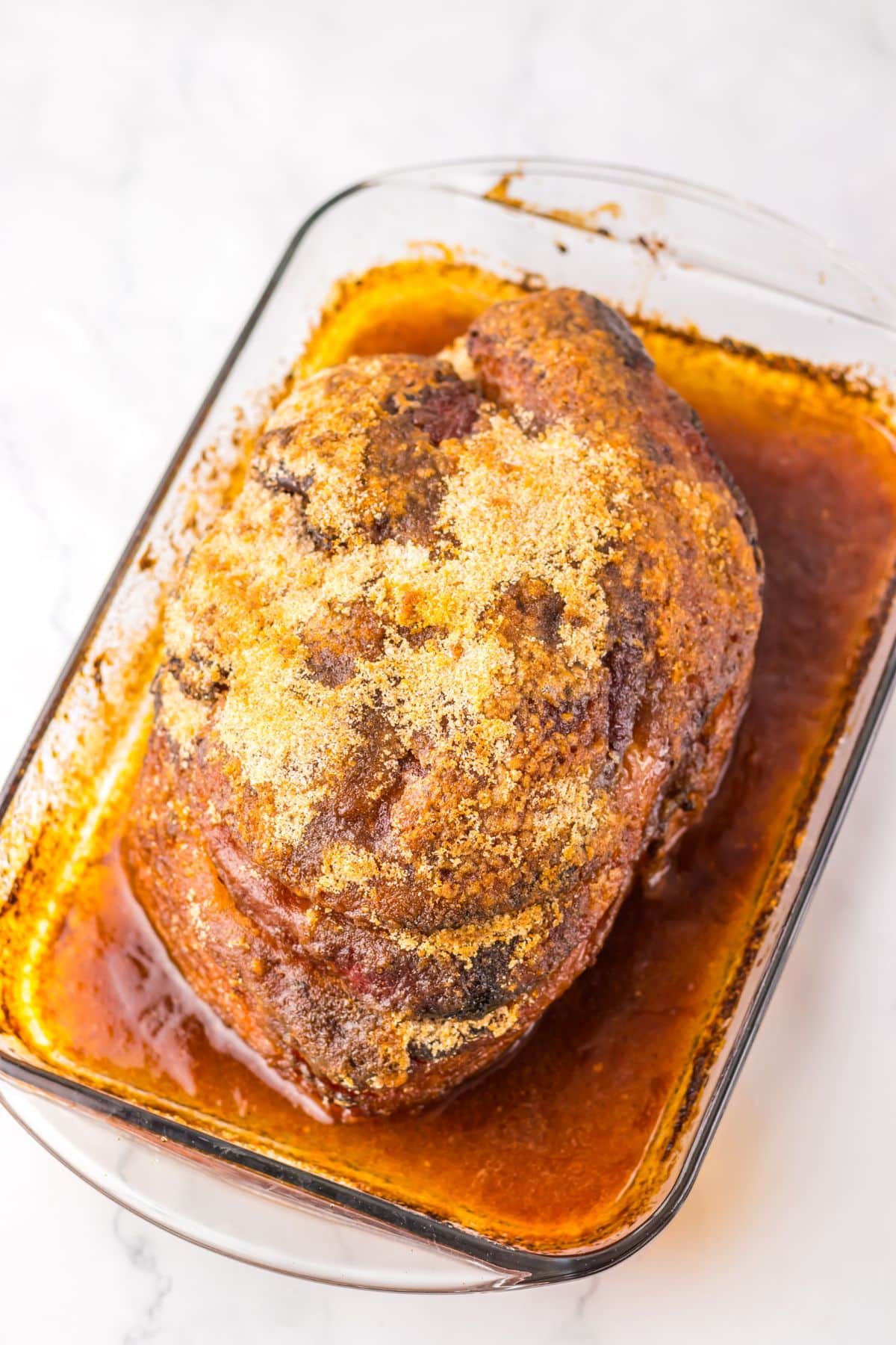 Cooked ham in a baking dish.
