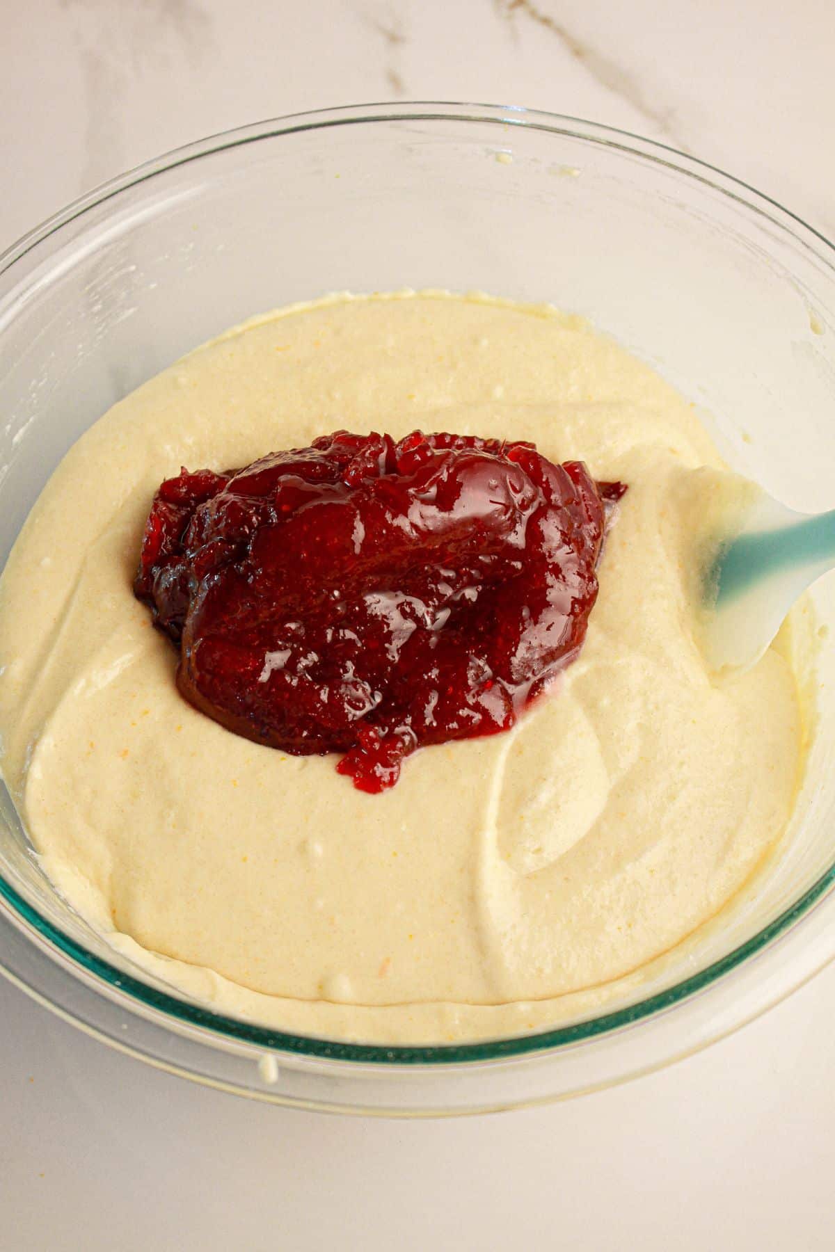 Cranberry sauce being added to batter.