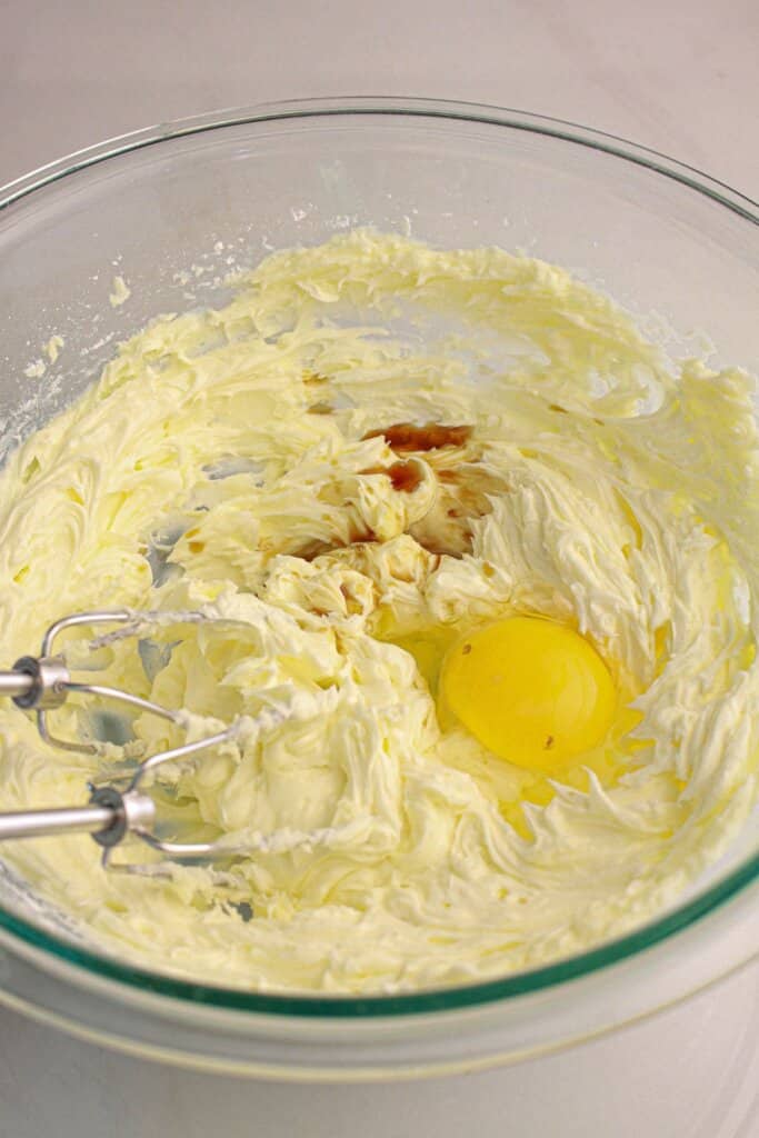 Eggs being added to a glass bowl.
