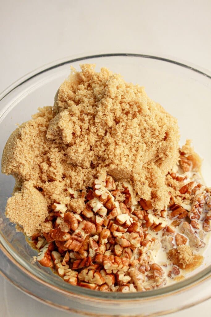 Brown sugar, pecans, and cream being mixed together.