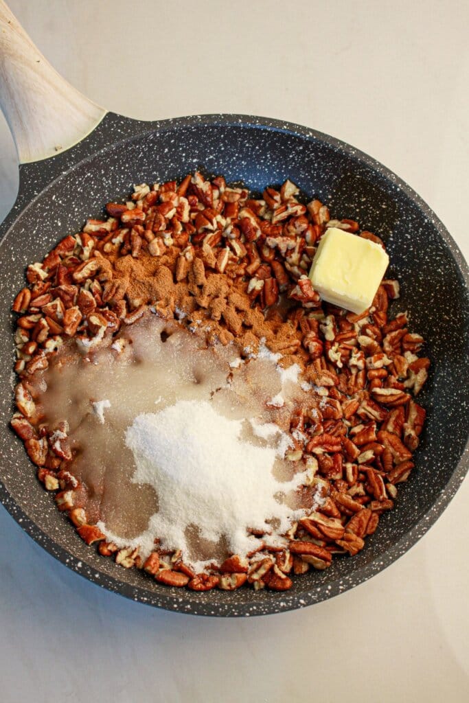 Pecans, butter, and sugar in a skillet.