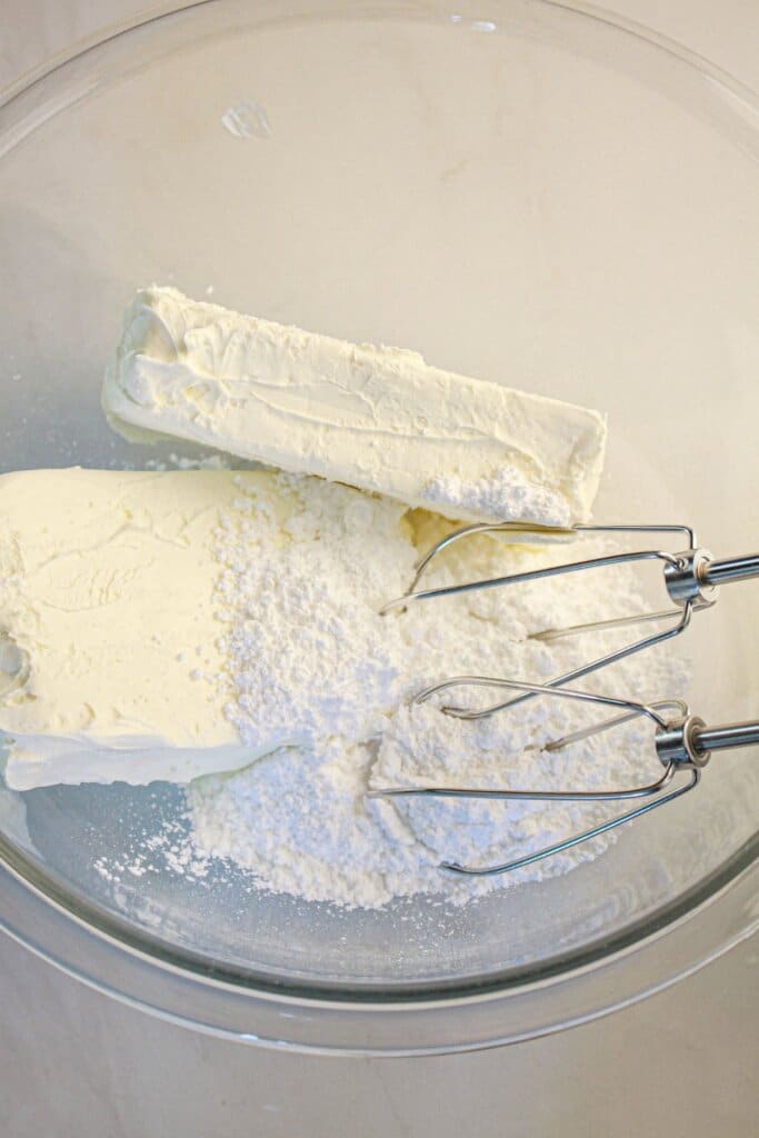 Cream cheese and powdered sugar being mixed together.