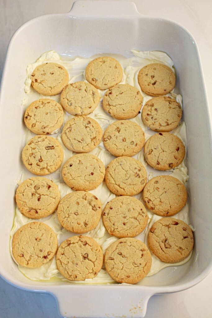 Sandies being laid into a baking dish.