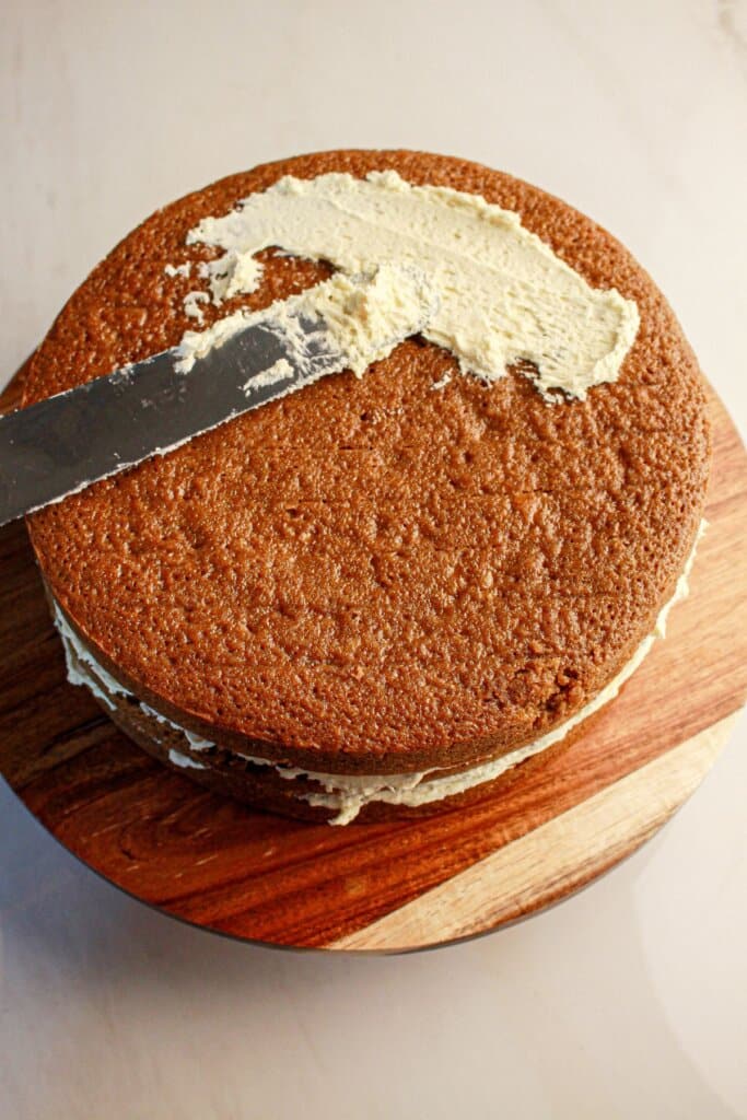 Frosting being spread on cake.