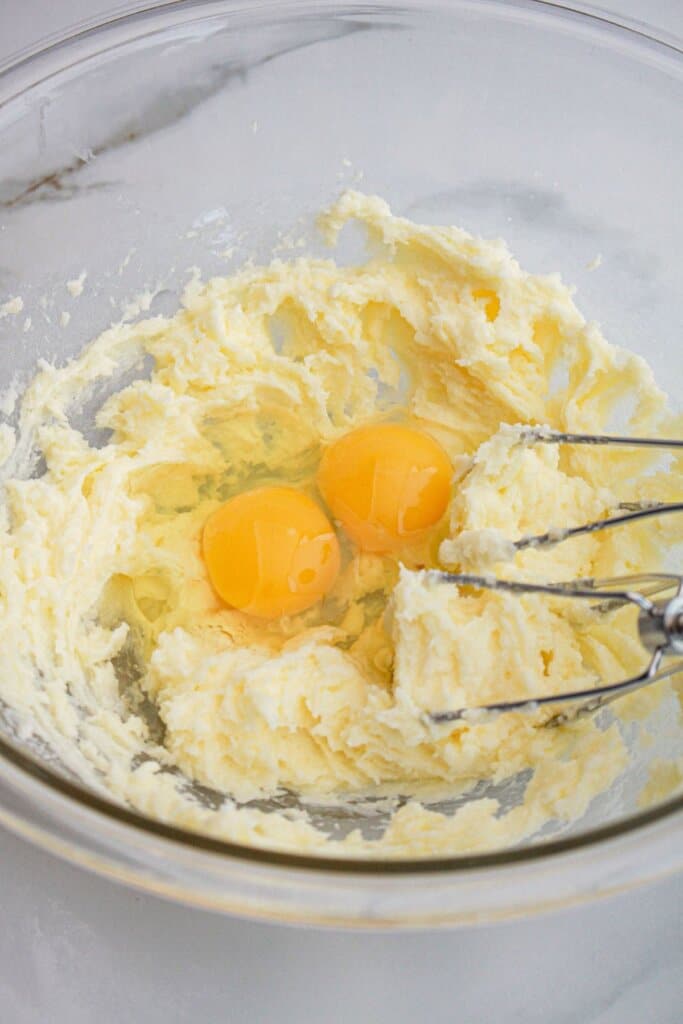 Butter and eggs in a glass mixing bowl.