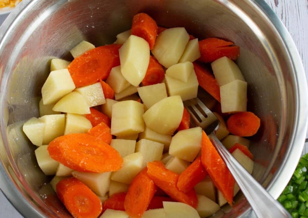 Potatoes and carrots in a mixing bowl.