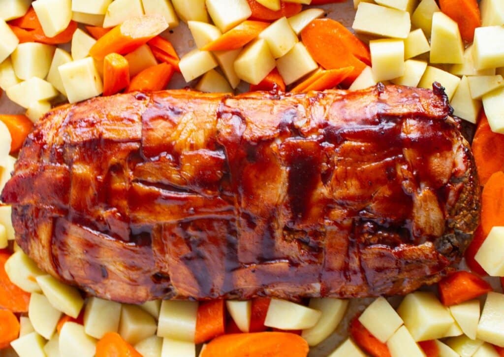 Meatloaf and vegetables on a baking sheet.