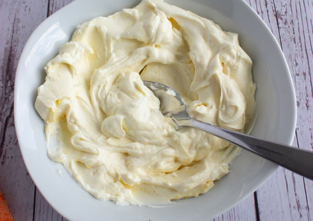 Cream cheese and garlic mixed in a bowl.