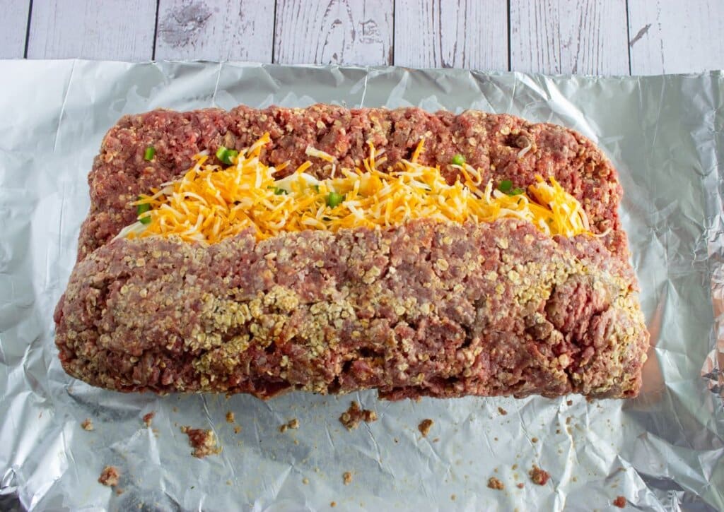 Meatloaf being rolled on foil.