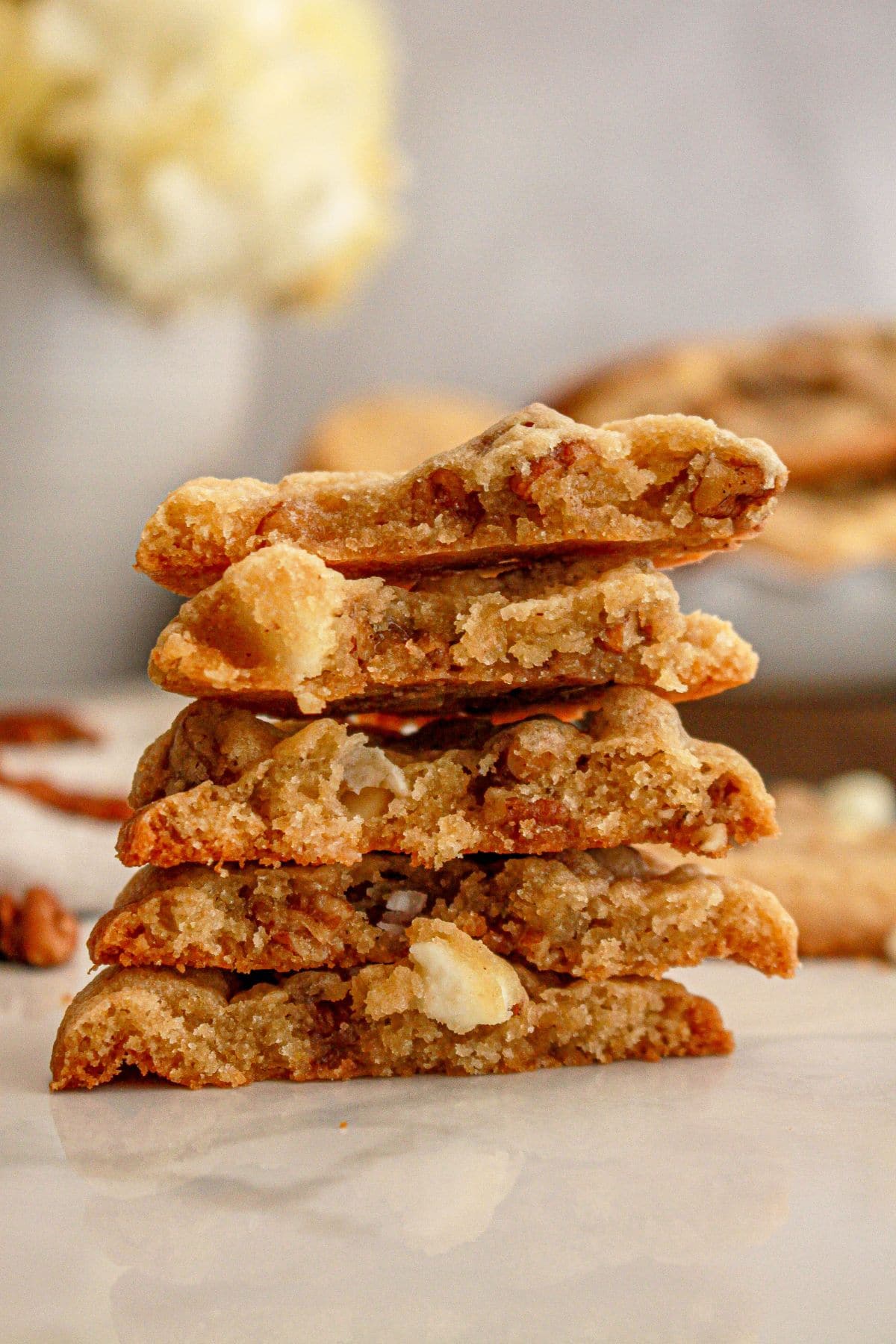 Butter pecan cookies broken in half stacked on top of each other.