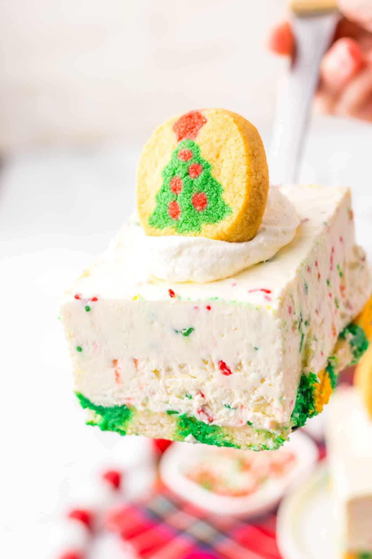 Slice of Christmas cheesecake bar on a spatula.