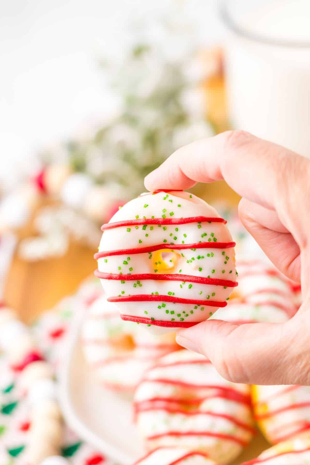 Christmas tree cake donut held in a woman's hand.