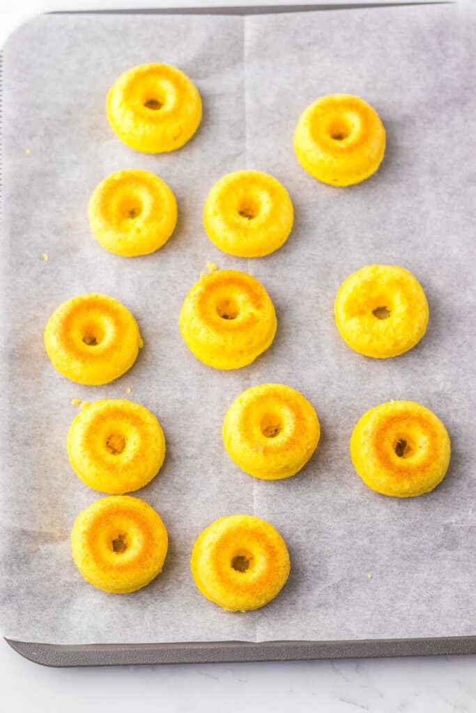 Donuts on a parchment lined baking sheet.