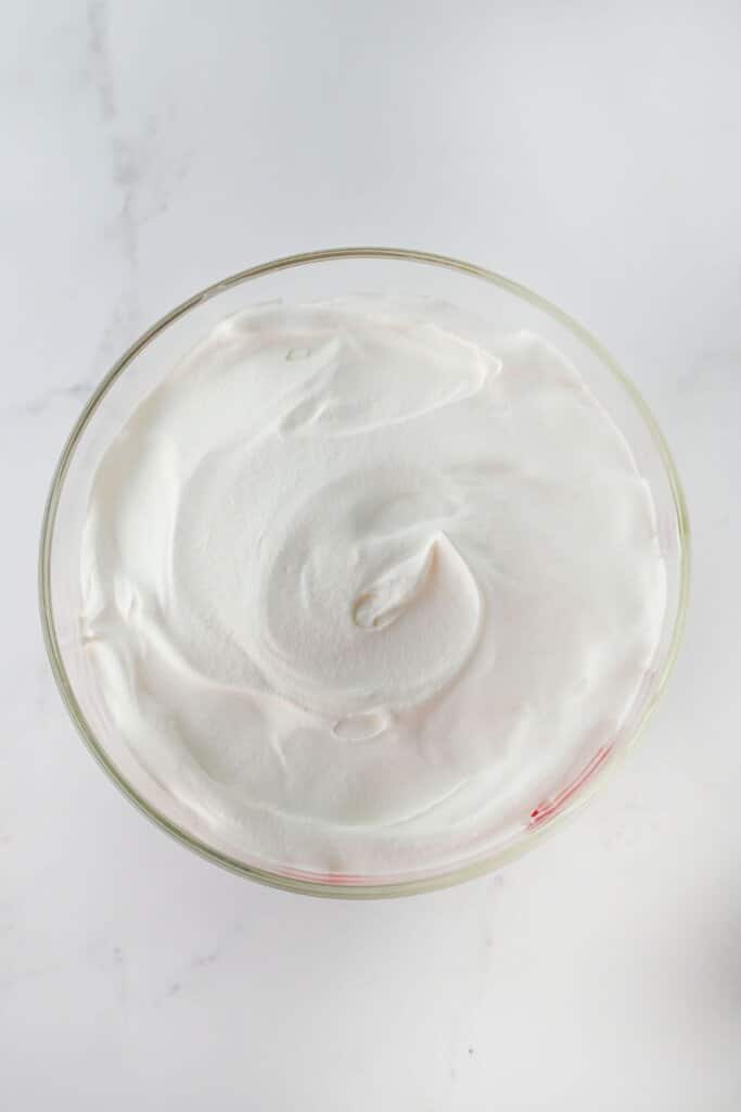 Whipped cream being spread on top of dessert.
