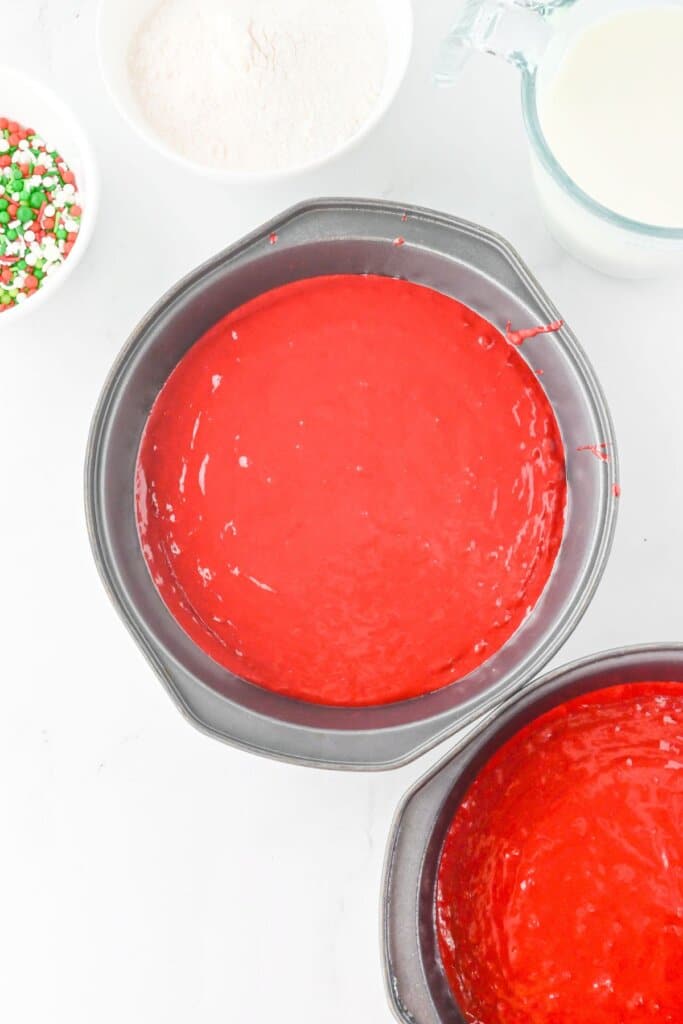 Red velvet cake batter in two cake pans.