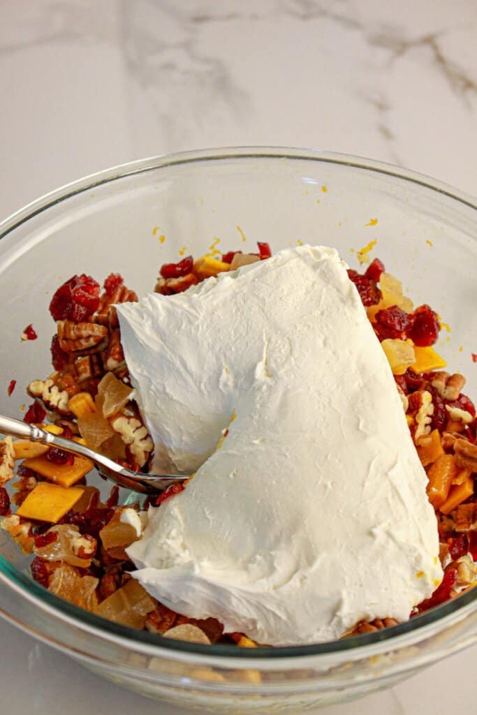 Cream cheese being added to a bowl.
