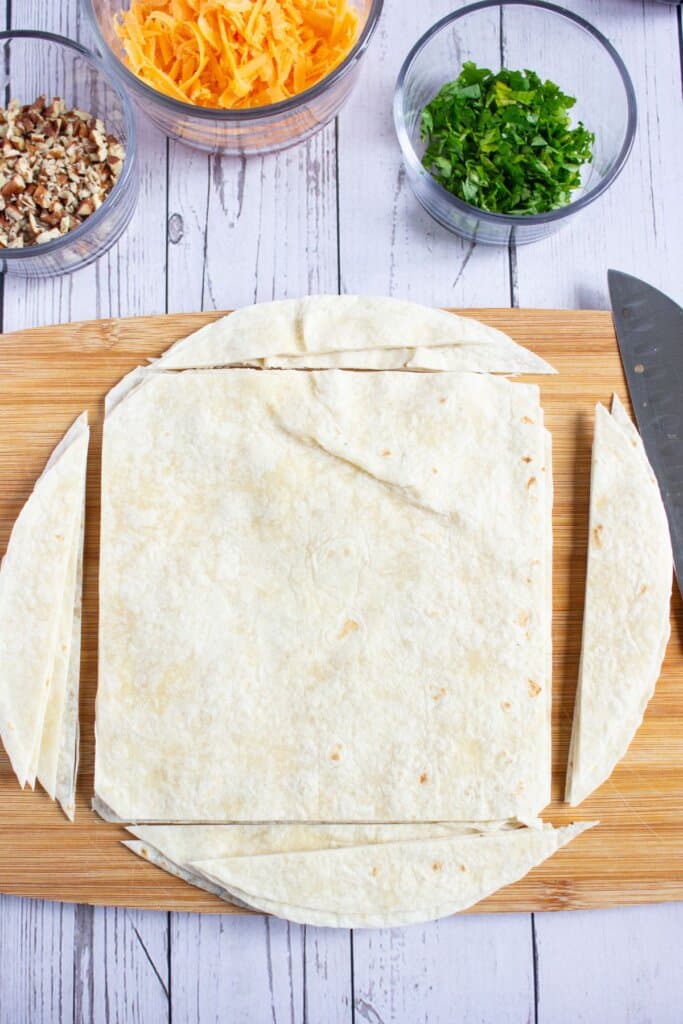 Tortillas being cut into squares.