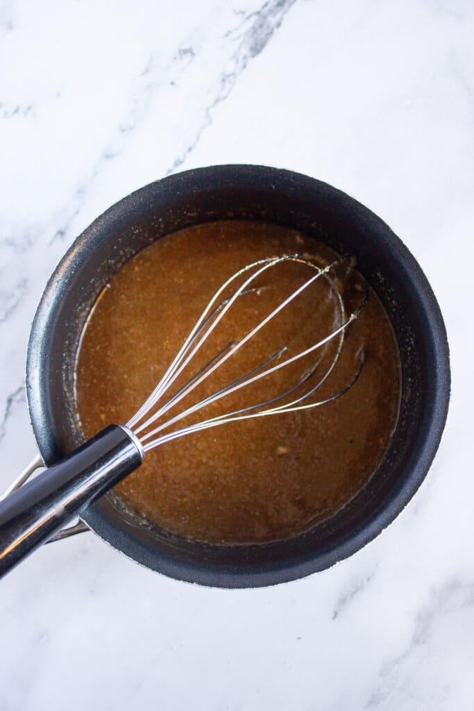 Glaze being whisked in a saucepan.