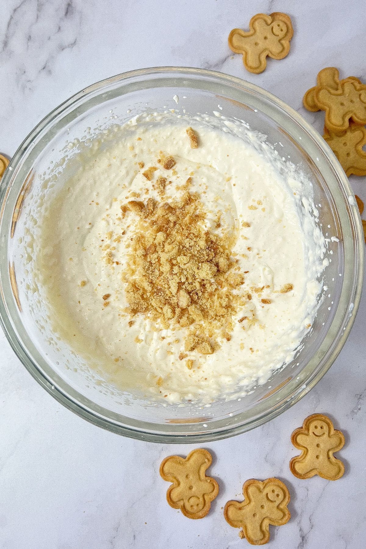 Gingerbread crumbs being added to cheesecake.