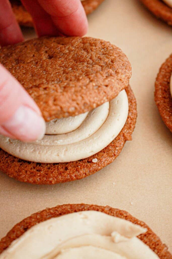 Sandwich cookies being stacked.