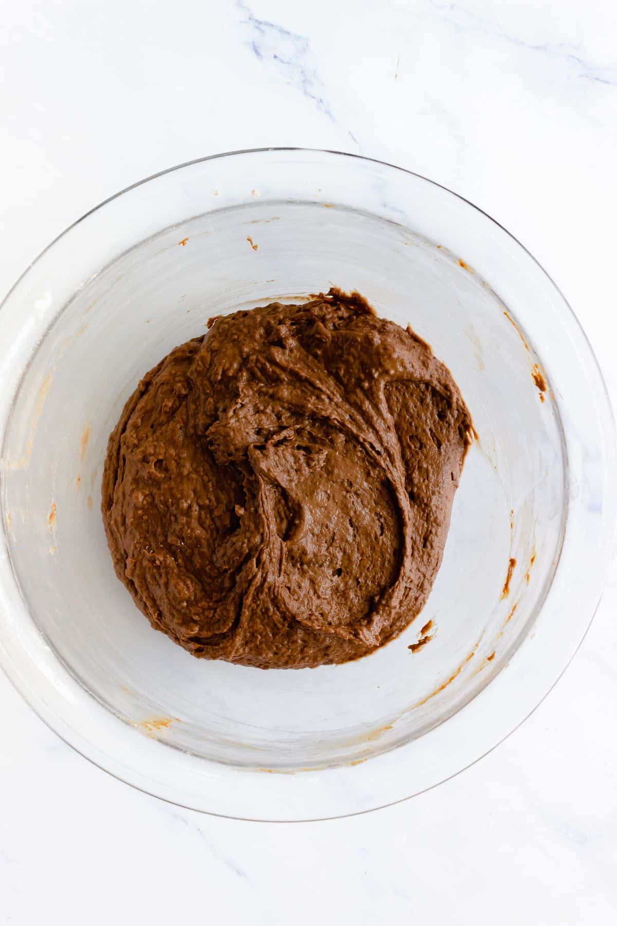 Chocolate dough in a glass mixing bowl.