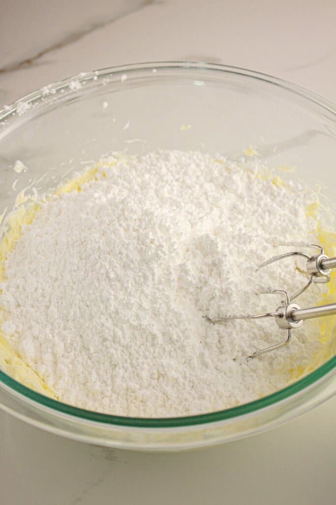 Frosting being mixedi in a glass bowl.