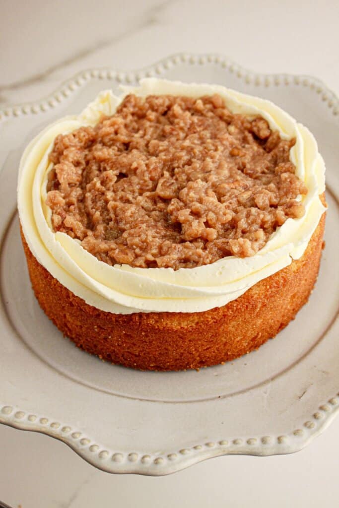 Frosting and filling being added to a cake.