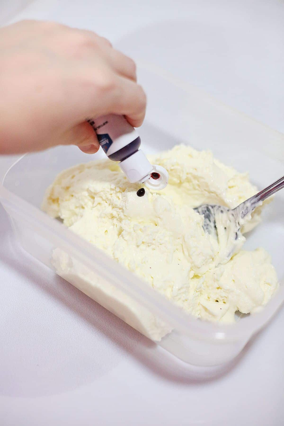 Food coloring being added to cheesecake filling.
