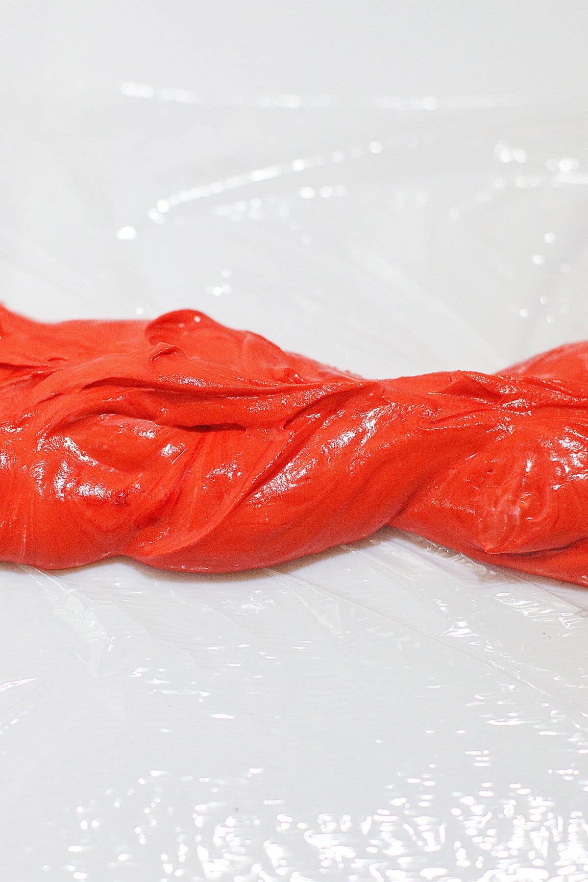 Cheesecake filling being added to plastic wrap.