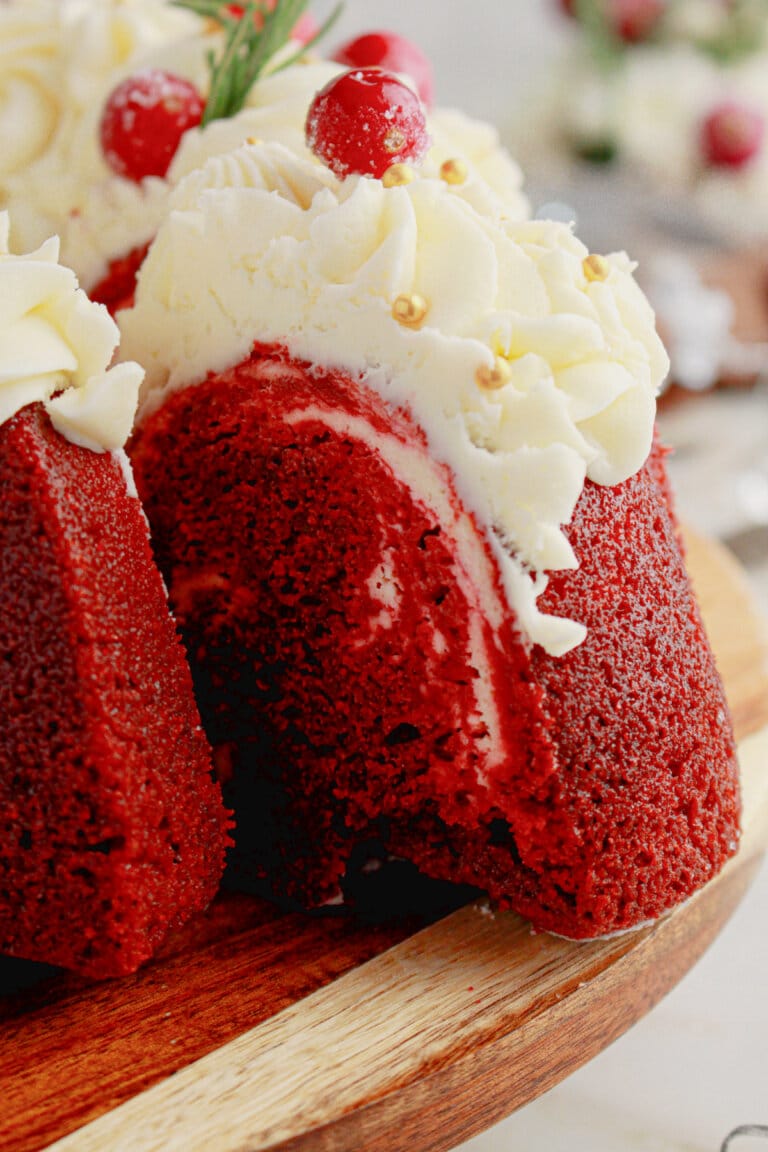Slice of red velvet bundt cake being removed from a board.