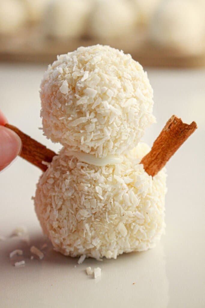 Cinnamon sticks being added to snowman truffle.