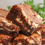 Cream cheese swirl brownies stacked on a cake stand.