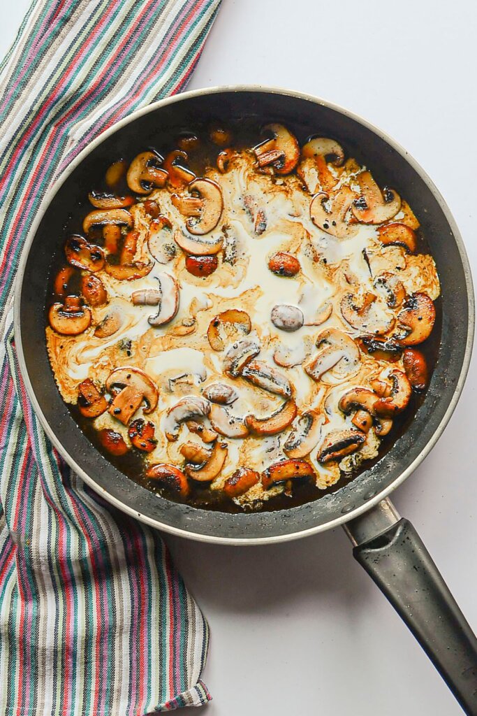 Cream being added to a skillet.