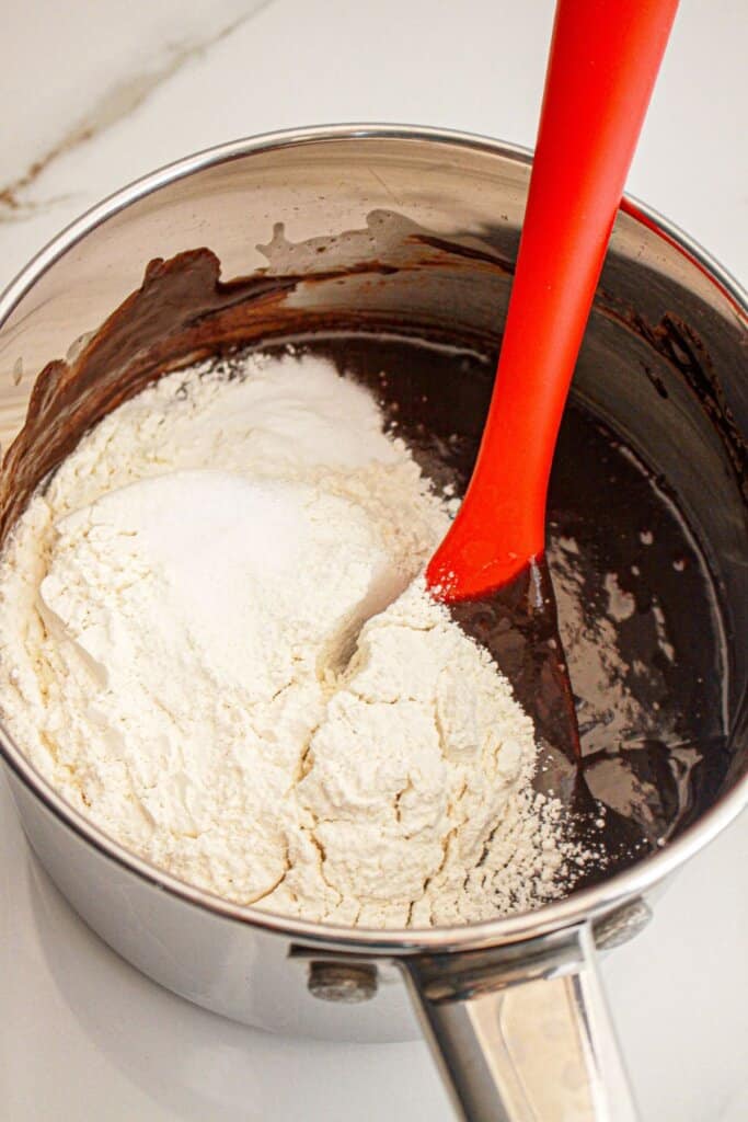 Flour being added to saucepan.