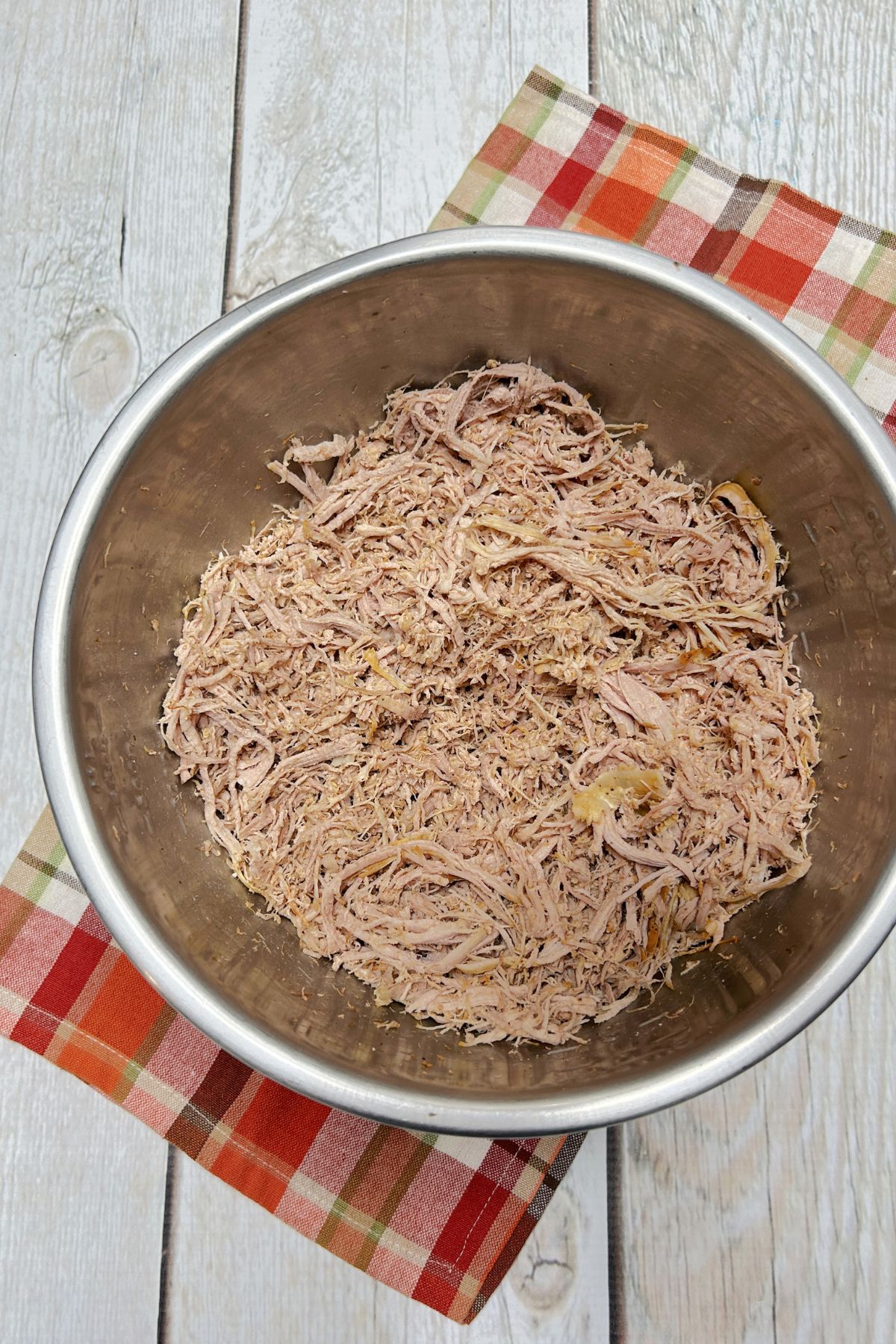 Shredded pork in a large mixing bowl.