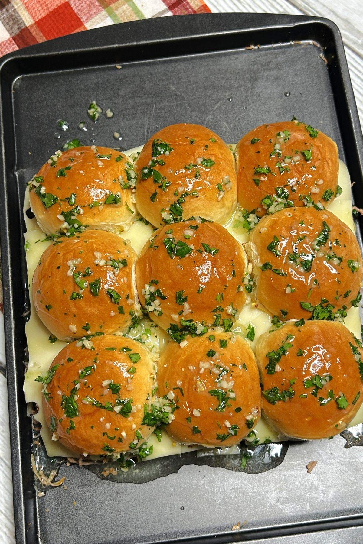 Sliders on a baking sheet ready for the oven.
