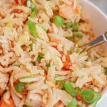 Bowl full of chicken fried rice on a counter.