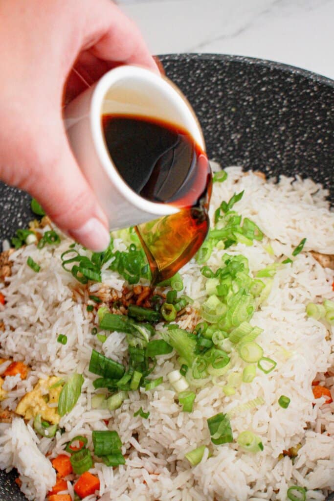 Soy sauce being poured into a skillet.