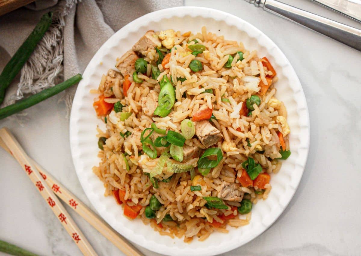 Bowl full of chicken fried rice on a counter.