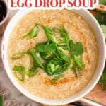 Bowl full of egg drop soup and garnished on cilantro and green onions.