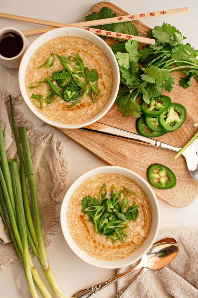Two bowls of egg drop soup on a counter.