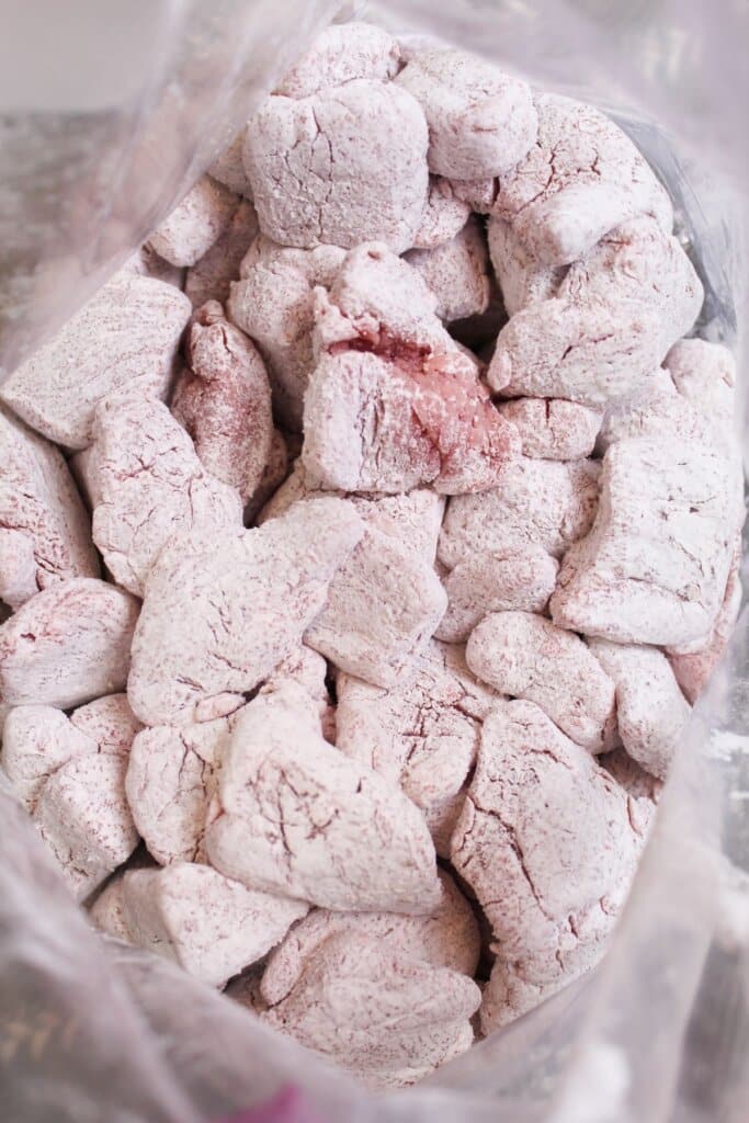 Beef being coated in cornstarch.