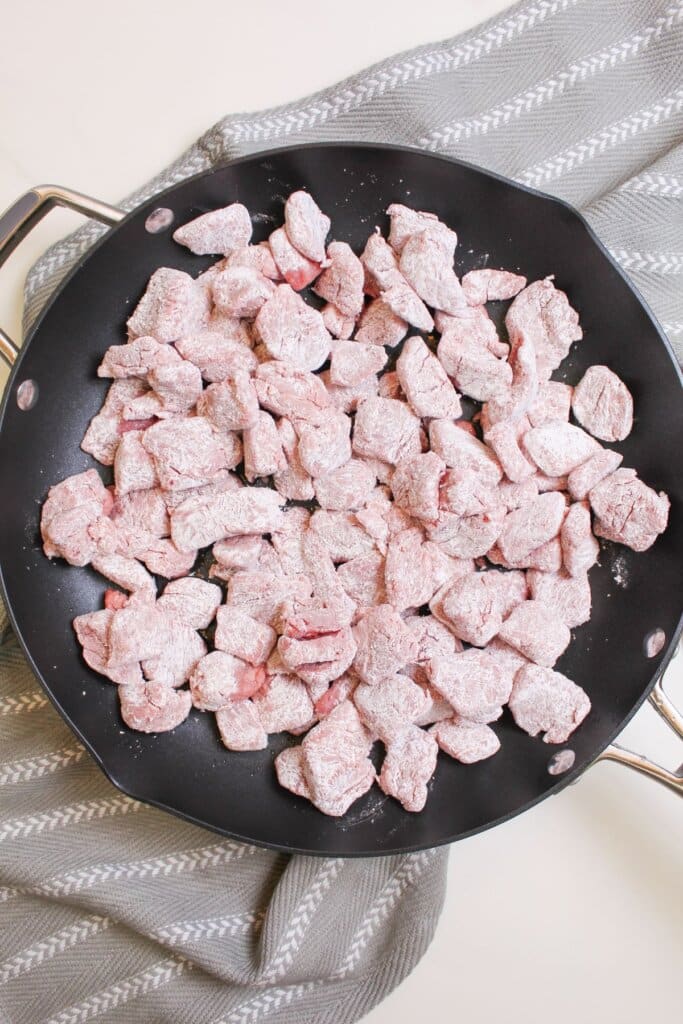 Beef being cooked in a skillet.