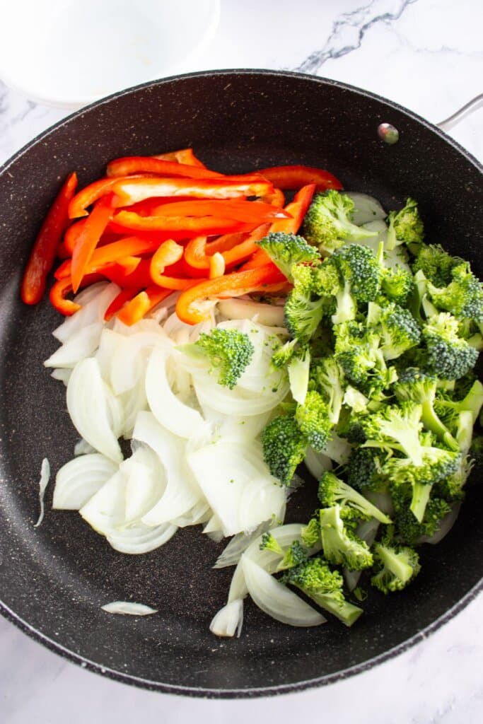 Broccoli, peppers, and onions in a skillet.