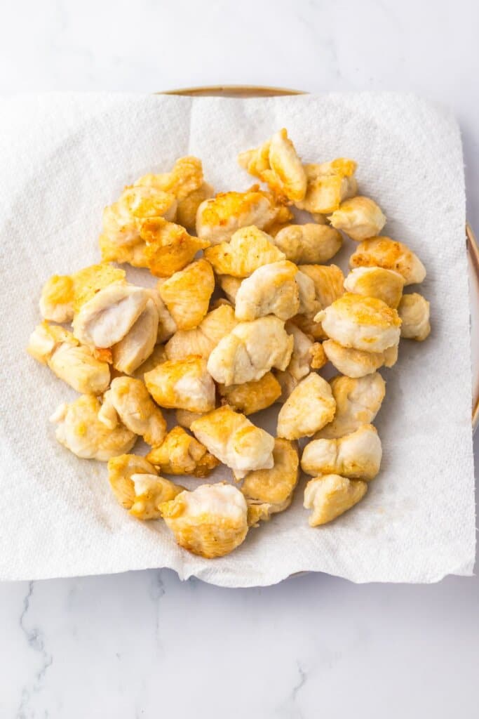 Chicken breats on a paper towel lined plate.
