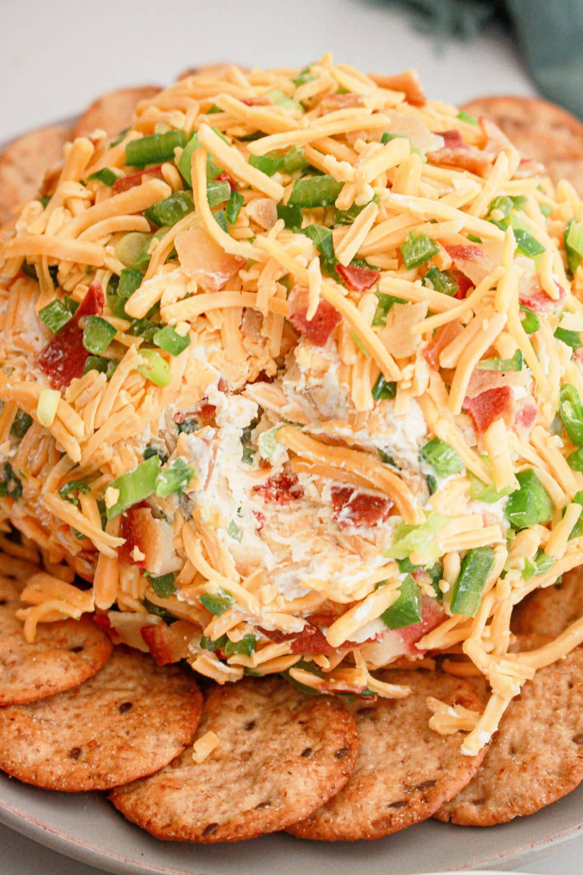 Cheese ball surrounded by crackers on a platter.