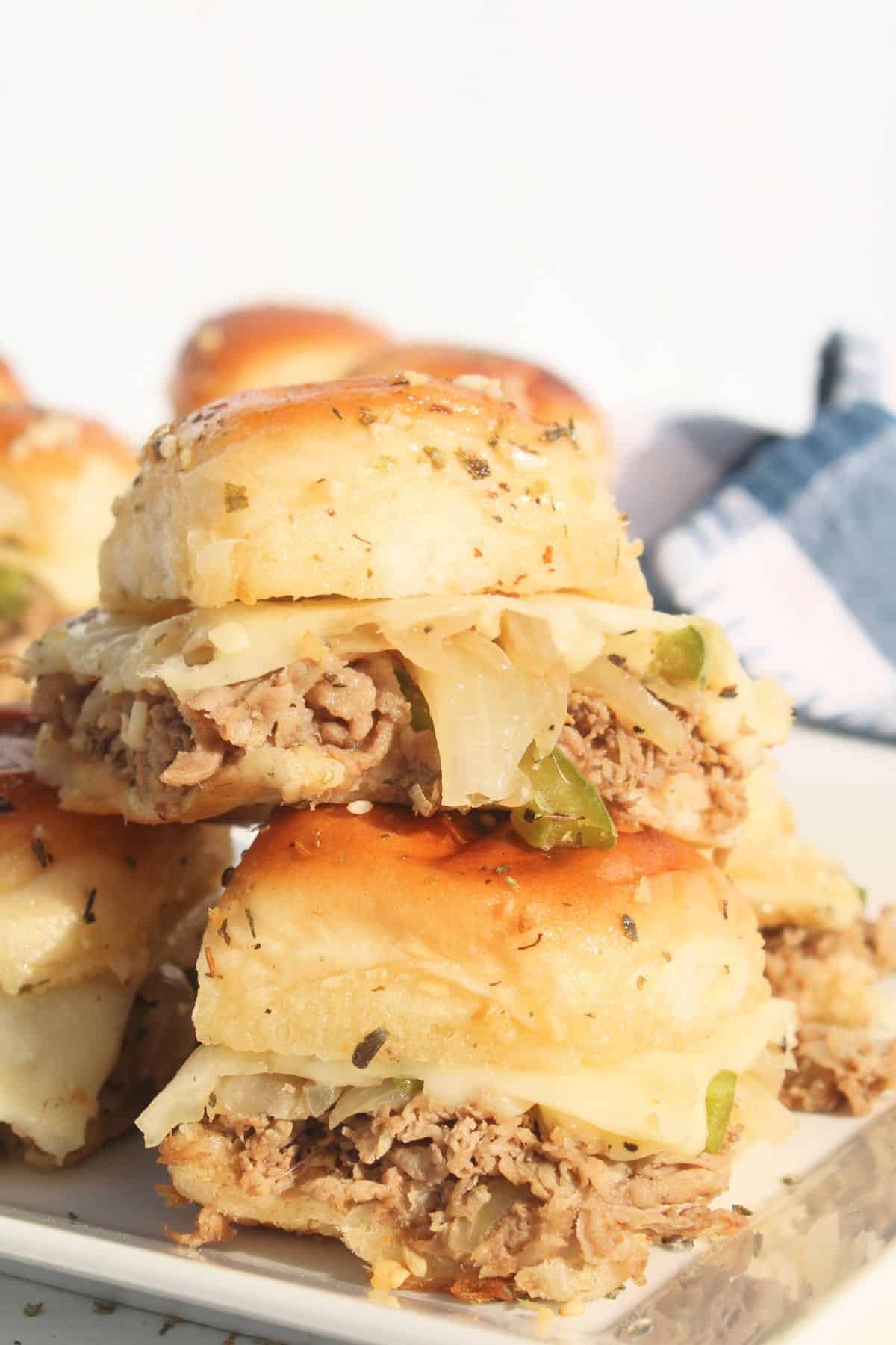 Philly cheesesteak sliders on a plate.