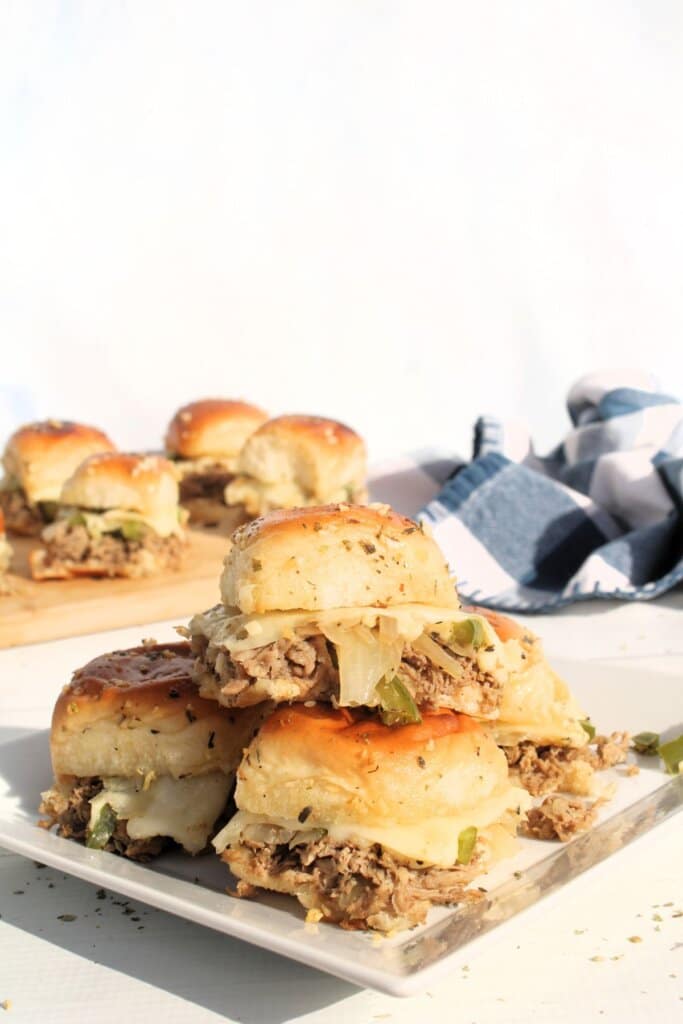 Philly cheesesteak sliders on a plate.