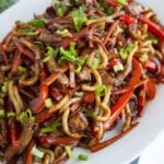 Bowl of pork lo mein on a table.