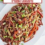 Bowl of pork lo mein on a table.
